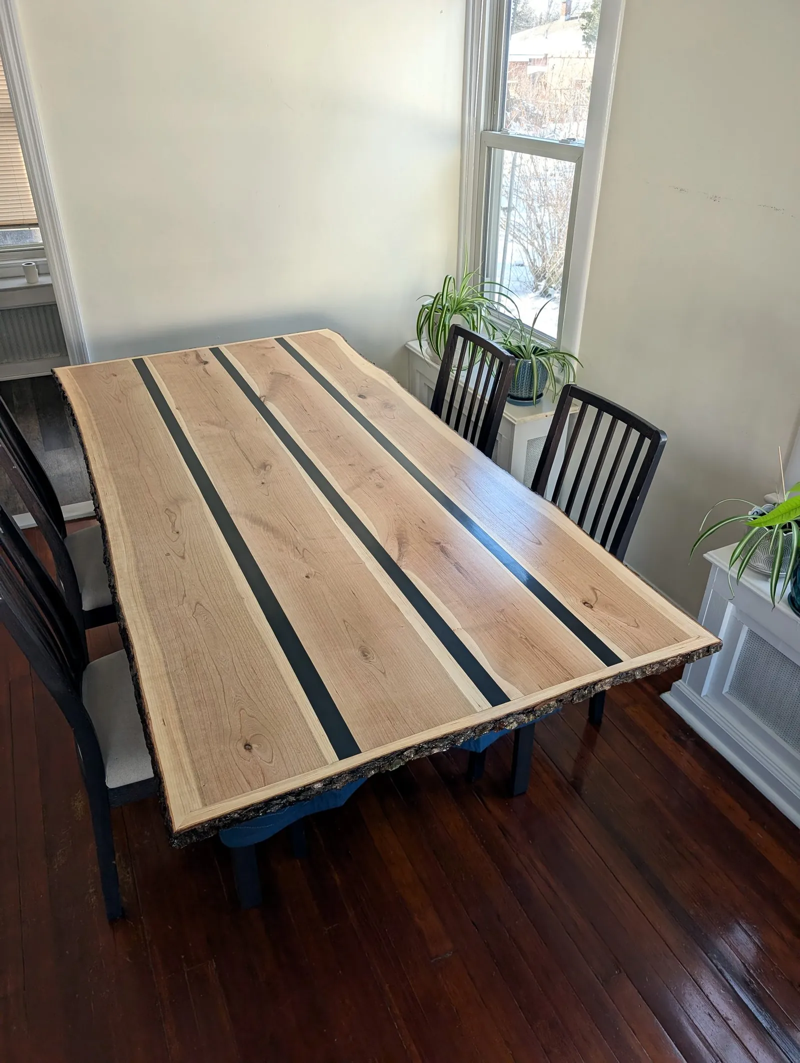 Red oak table with black epoxy stripe inlays and live bark edge