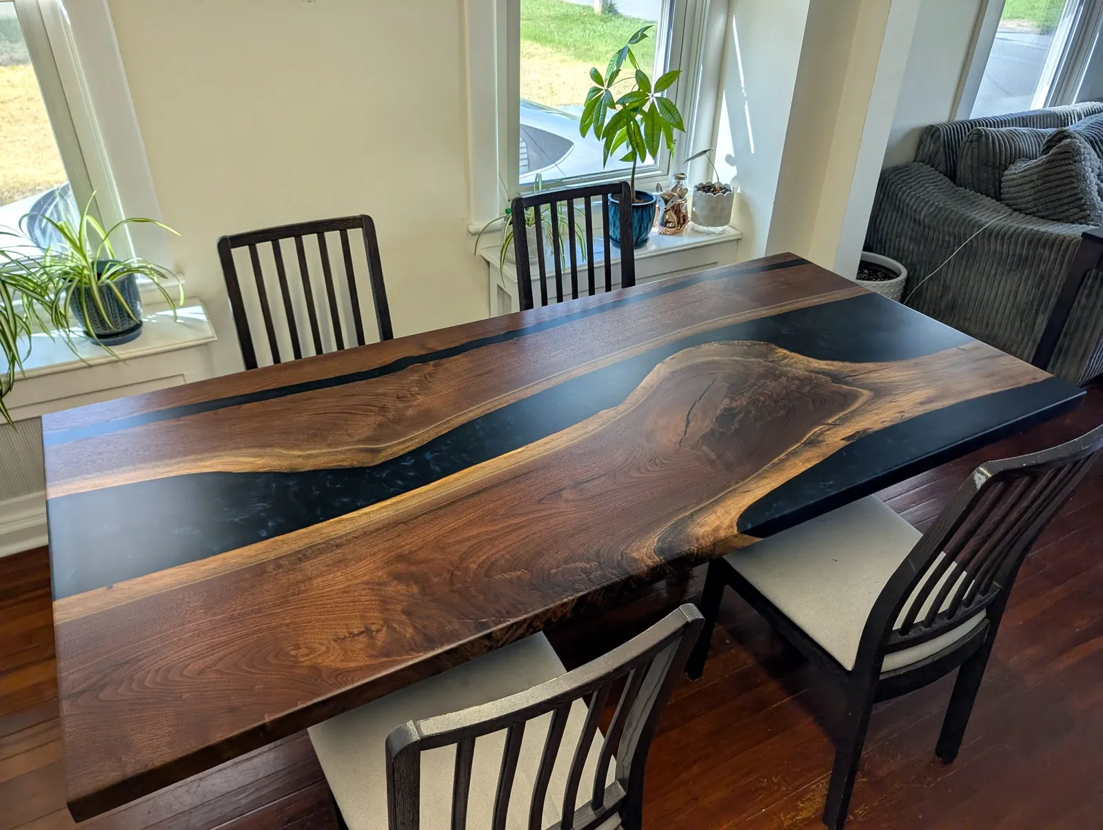 Black walnut river table with a deep blue epoxy river, dining room setting